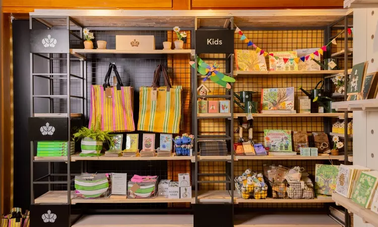 Wall display in the shop with childrens items. Colourful bunting, soft toys and books are on display. 