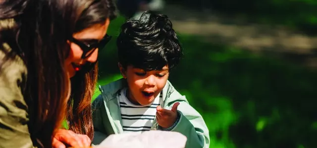 Parent and young boy looking at something in child's hand