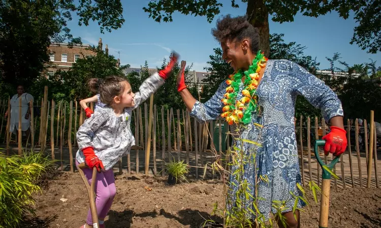 Woman and child digging in the flower beds